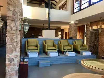 a waiting area with green chairs in a lobby at Vetho Farmhouse Dullstroom in Dullstroom