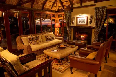 a living room with a couch and a fireplace at Nungubane Game Lodge in Welgevonden Game Reserve