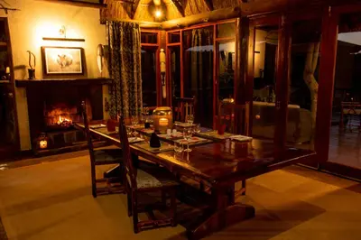a dining room with a table and a fireplace at Nungubane Game Lodge in Welgevonden Game Reserve