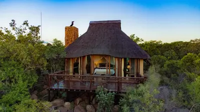 a small house with a thatched roof on a hill at Nungubane Game Lodge in Welgevonden Game Reserve