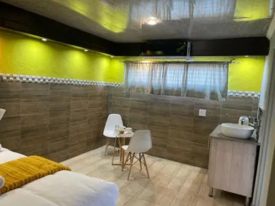 a bedroom with a bathroom with a sink and a bed at Ko-Khoneng Guest house in Lebowakgomo