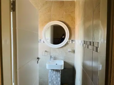 a bathroom with a sink and a mirror at Ko-Khoneng Guest house in Lebowakgomo