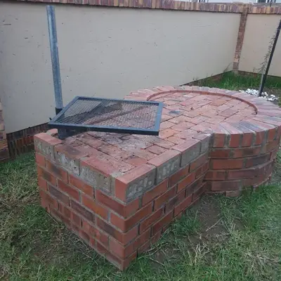 a brick fire pit with a grill on top of it at Lloyds - 3 in Ermelo