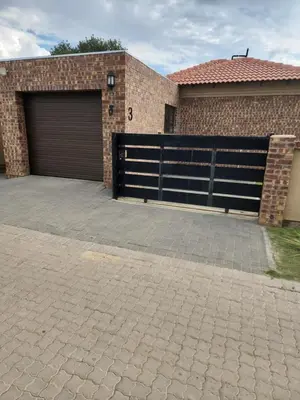 a garage with a garage door and a brick building at Lloyds - 3 in Ermelo