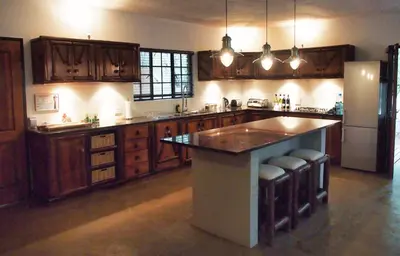 a large kitchen with wooden cabinets and a large island at Jabulani Bushhouse - Marlothpark in Marloth Park