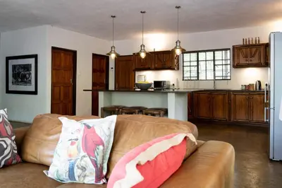 a living room with a couch and a kitchen at Jabulani Bushhouse - Marlothpark in Marloth Park