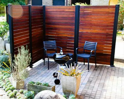 two chairs and a table in front of a fence at White River Country Estate Self Catering Apartment in White River