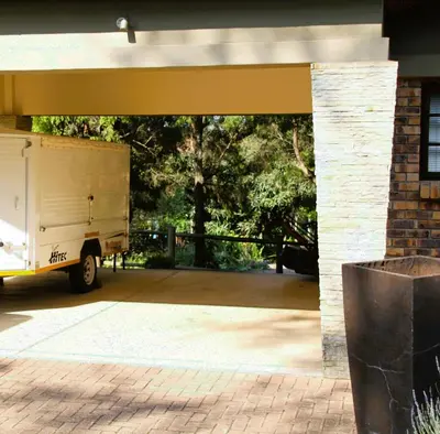 a garage with a truck parked under a building at White River Country Estate Self Catering Apartment in White River