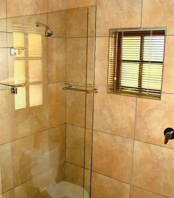 a bathroom with a shower with a glass door at White River Country Estate Self Catering Apartment in White River