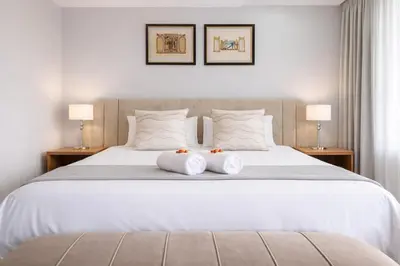 a bedroom with a white bed with two towels on it at Magalies Mountain Lodge and Spa in Hartbeespoort