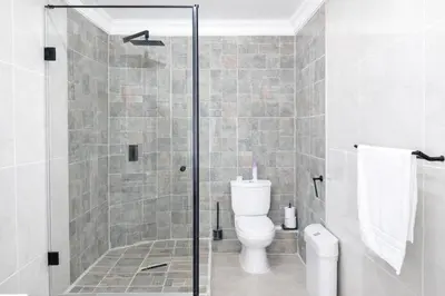 a bathroom with a toilet and a glass shower at Magalies Mountain Lodge and Spa in Hartbeespoort