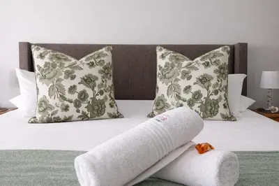 a injured leg sitting on a bed with pillows at Magalies Mountain Lodge and Spa in Hartbeespoort
