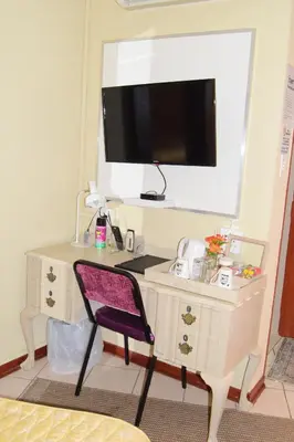 a desk with a chair and a tv on top of it at Tengo guest house in Phalaborwa