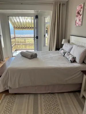 a bedroom with a large bed with a large window at La Prima Casa in Graskop