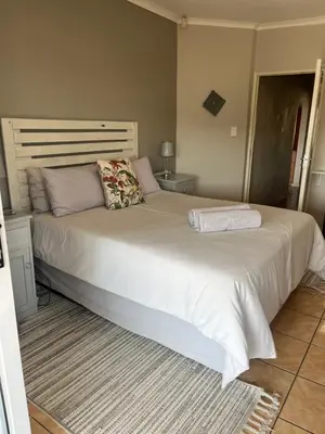 a large white bed with pillows on it in a bedroom at La Prima Casa in Graskop