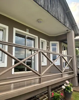 a house with a wooden railing on the front porch at La Prima Casa in Graskop
