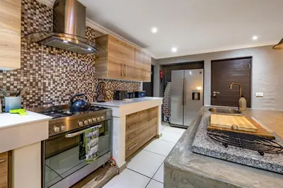 a kitchen with a stove top oven next to a counter at Wildheart Safari - MAIN in Hoedspruit