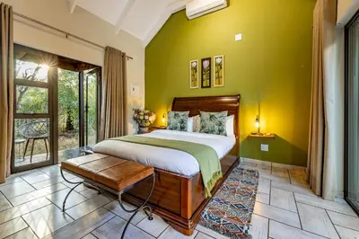 a bedroom with a bed and a green wall at Wildheart Safari - MAIN in Hoedspruit