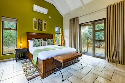 a bedroom with a large bed and green walls at Wildheart Safari - MAIN in Hoedspruit