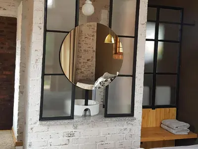 a mirror on the wall of a bathroom at The Stables At Critchley in Dullstroom