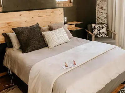 a bedroom with a large bed with two figurines on it at The Stables At Critchley in Dullstroom
