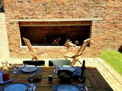 a table and chairs with a fire place in the background at The Stables At Critchley in Dullstroom