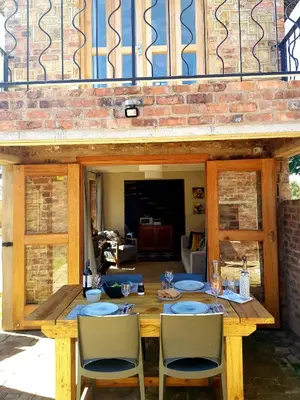 a wooden table with chairs and wine glasses at The Stables At Critchley in Dullstroom