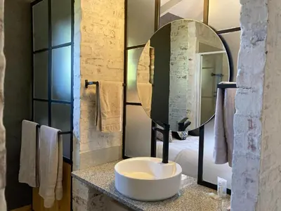 a bathroom with a white sink and a mirror at The Stables At Critchley in Dullstroom