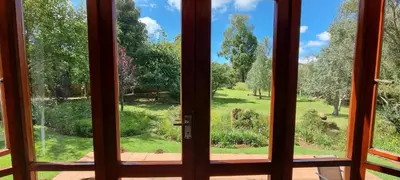 a view from a door looking out into a garden at DullVino Cottage no 15 at Critchley in Dullstroom
