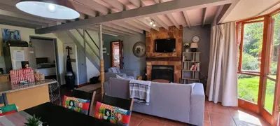 a living room with a couch and a tv at DullVino Cottage no 15 at Critchley in Dullstroom