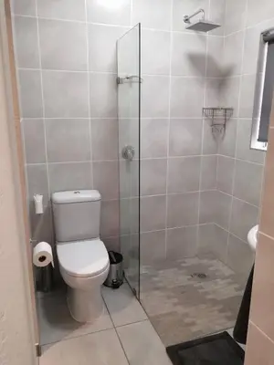 a bathroom with a toilet and a glass shower at 394OnEmus in Pretoria