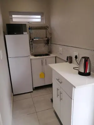 a kitchen with a refrigerator and a tea kettle on the counter at 394OnEmus in Pretoria