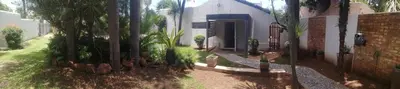a house with a bunch of palm trees in front of it at 394OnEmus in Pretoria