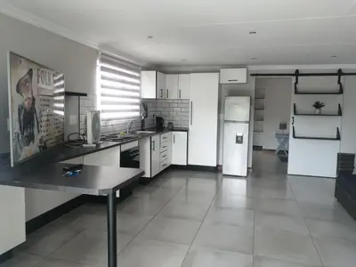 a kitchen with a refrigerator and a table in it at 394OnEmus in Pretoria