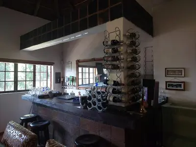 a room with a bar with a bunch of wine glasses at Garrett B&B in Pretoria