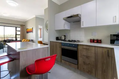 a kitchen with a red chair in a kitchen at Alimama Spaces: The Thando's Kyalami Woods in Midrand