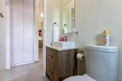 a bathroom with a white toilet and a sink at Alimama Spaces: The Thando's Kyalami Woods in Midrand
