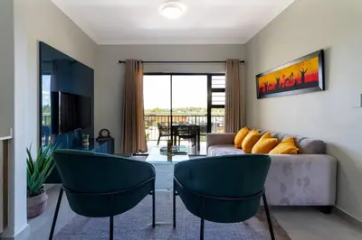 a living room with a couch and two chairs at Alimama Spaces: The Thando's Kyalami Woods in Midrand