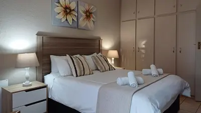 a bedroom with a bed with two towels on it at Georeen Guest House in Polokwane