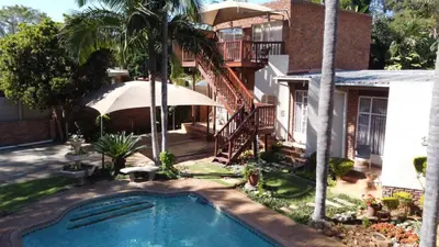 a swimming pool in front of a house at Georeen Guest House in Polokwane