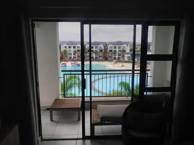 a room with a view of a pool from a balcony at Breathtaking Lagoon View Apartment @ The Blyde1531 in Pretoria