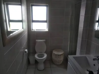 a bathroom with a toilet and a sink and a window at Breathtaking Lagoon View Apartment @ The Blyde1531 in Pretoria