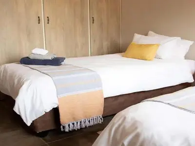 two beds in a small room withermottermott at East of East Guest Cottage in Avondzon