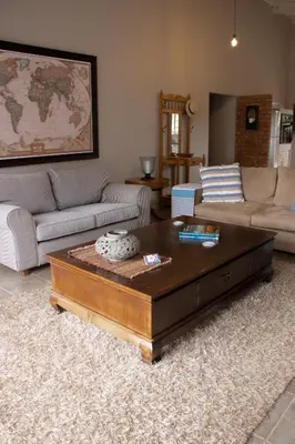 a living room with a couch and a coffee table at East of East Guest Cottage in Avondzon