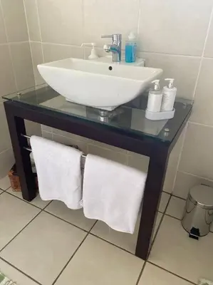 a bathroom with a sink and towels on a table at Garden and Park Leisure on Tugela in Benoni