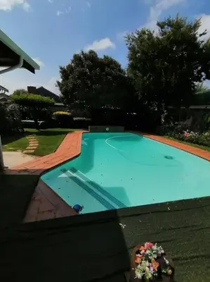 an empty swimming pool in front of a house at Garden and Park Leisure on Tugela in Benoni