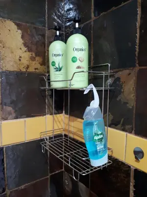 two bottles of cleaning products on a rack on a wall at 13th Avenue Guesthouse Benoni in Benoni