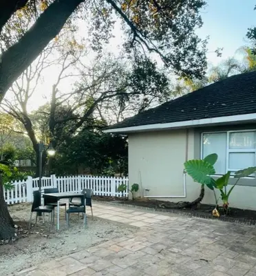 a table and chairs in front of a house at Grace Gardens - Grace in Pretoria
