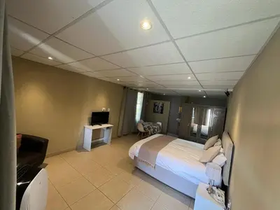 a bedroom with a bed and a television in a room at Koi Inn in Hartbeespoort