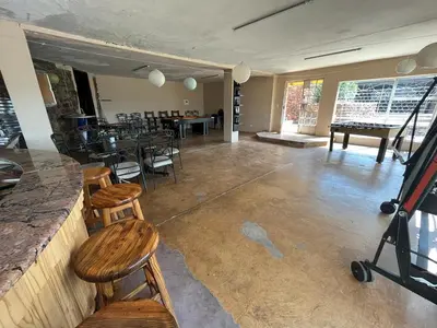a room with a bar with chairs and a table at Koi Inn in Hartbeespoort